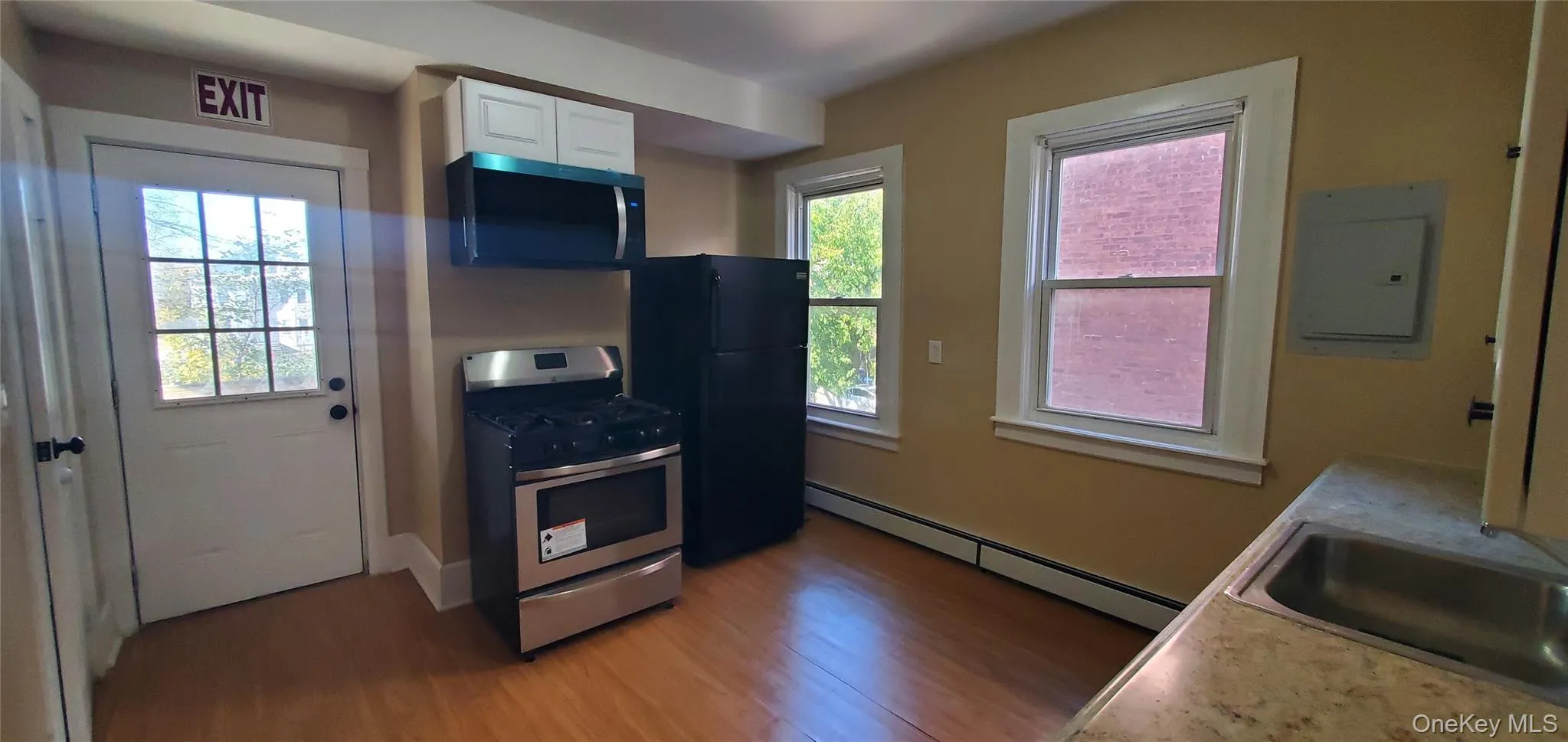 Kitchen featuring stainless steel range with gas stove, microwave, wood finished floors Kitchen featuring stainless steel range with gas stove, microwave, wood finished floors