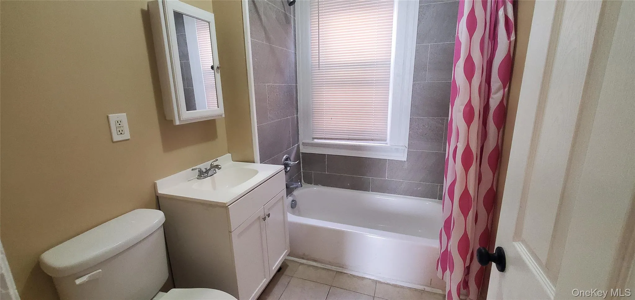 Full bath with vanity, light tile patterned floors, and shower / bath combo Full bath with vanity, light tile patterned floors, and shower / bath combo