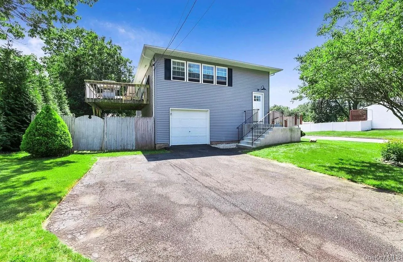 View of front facade featuring driveway and a garage View of front facade featuring driveway and a garage