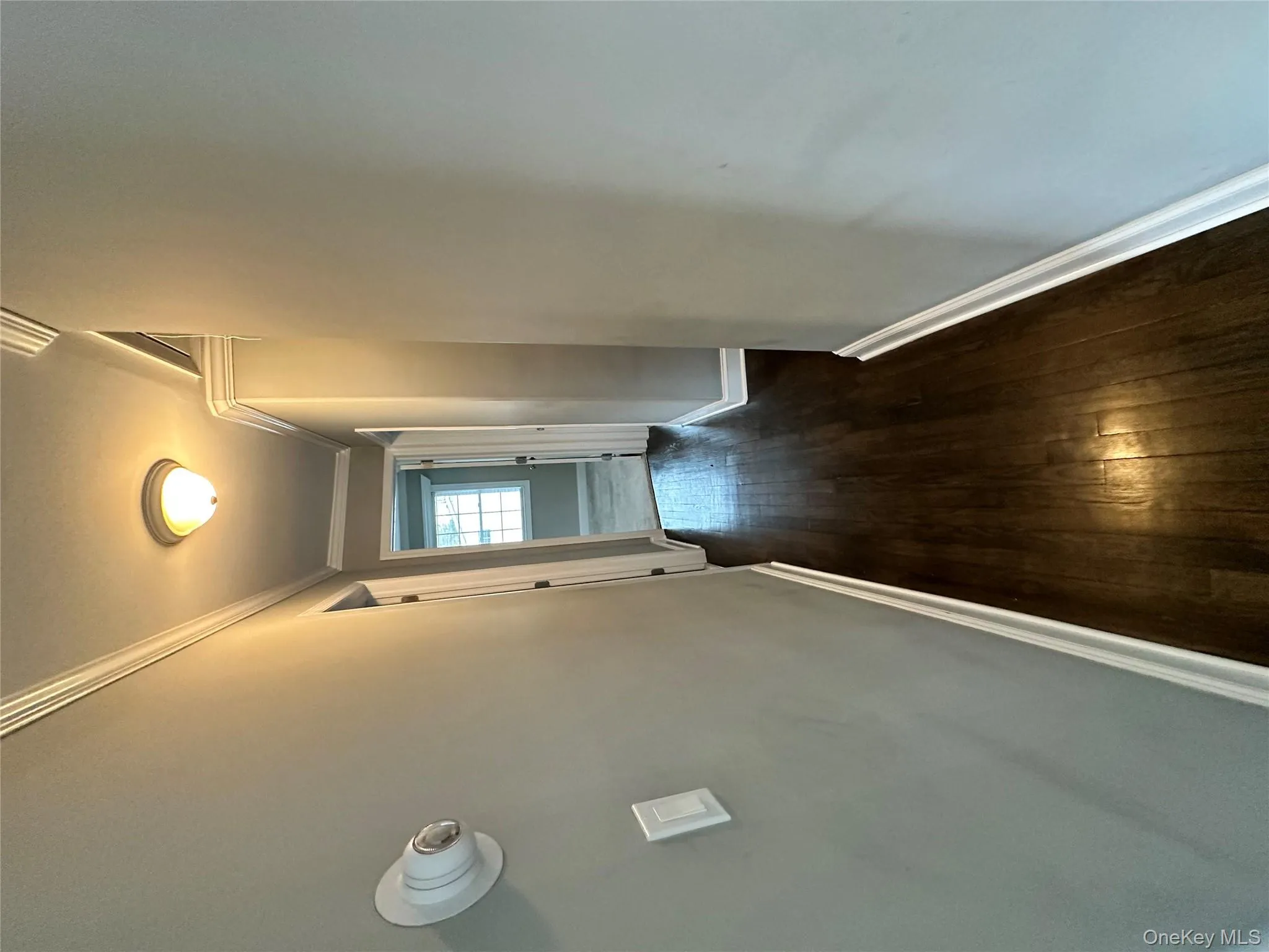 Corridor featuring dark wood-type flooring and ornamental molding Corridor featuring dark wood-type flooring and ornamental molding