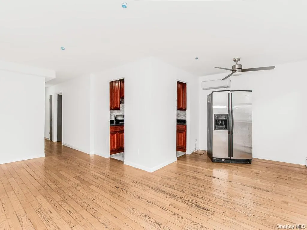 Empty room with light wood-style floors and a ceiling fan Empty room with light wood-style floors and a ceiling fan