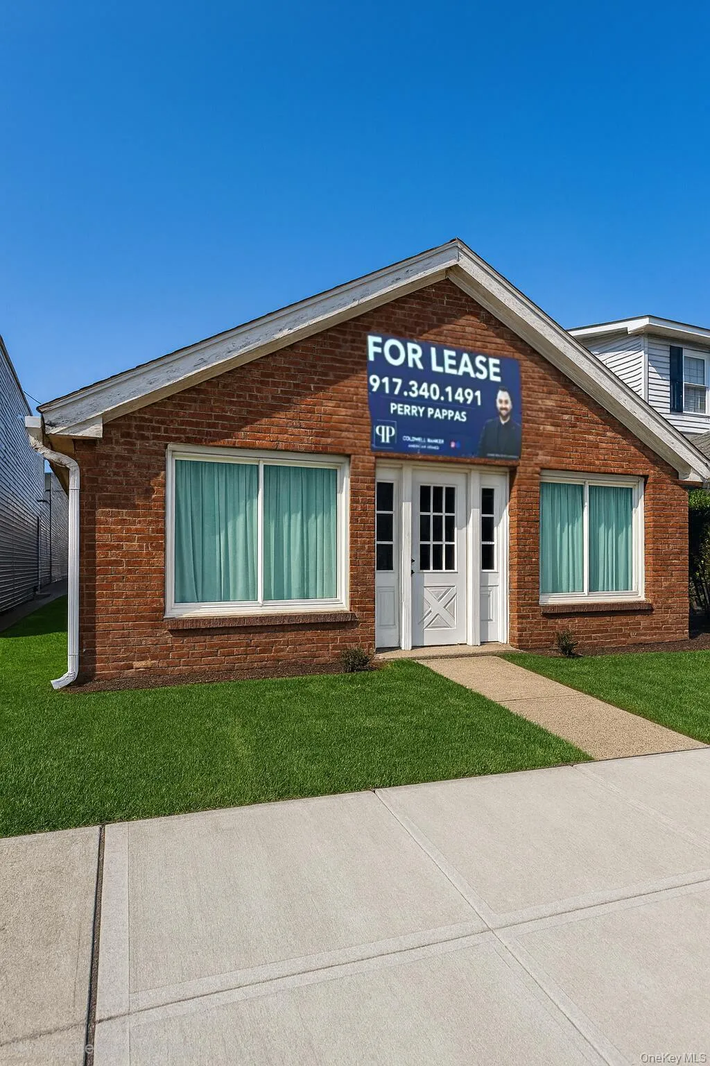 Doorway to property featuring brick siding and a lawn Doorway to property featuring brick siding and a lawn