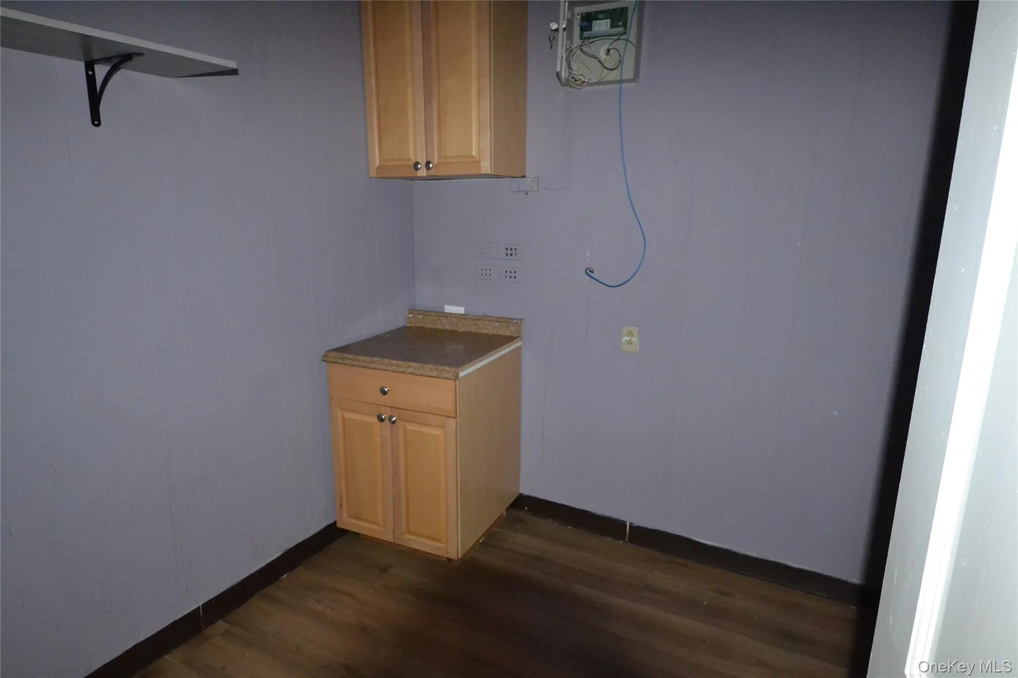 Laundry room featuring dark wood-type flooring and baseboards Laundry room featuring dark wood-type flooring and baseboards