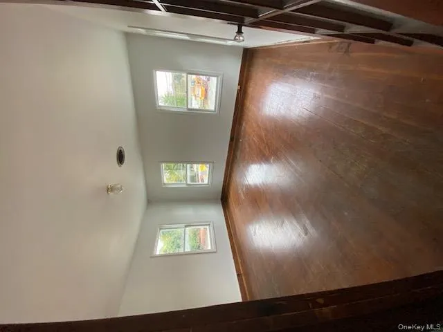 Unfurnished room featuring baseboards and dark wood-style flooring Unfurnished room featuring baseboards and dark wood-style flooring