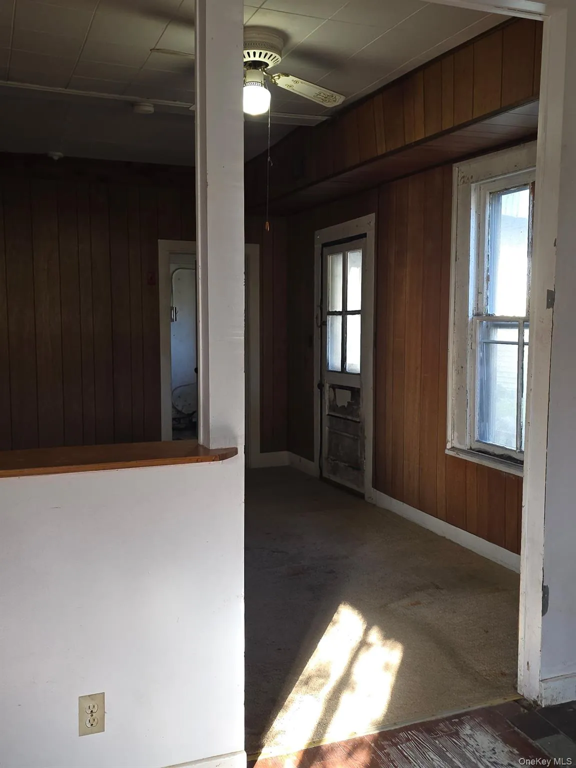 Foyer featuring wood walls and a ceiling fan Foyer featuring wood walls and a ceiling fan