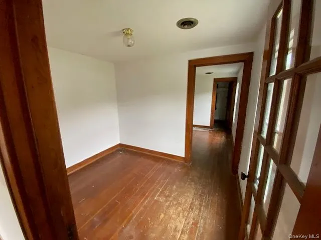 Spare room with dark wood finished floors and baseboards Spare room with dark wood finished floors and baseboards