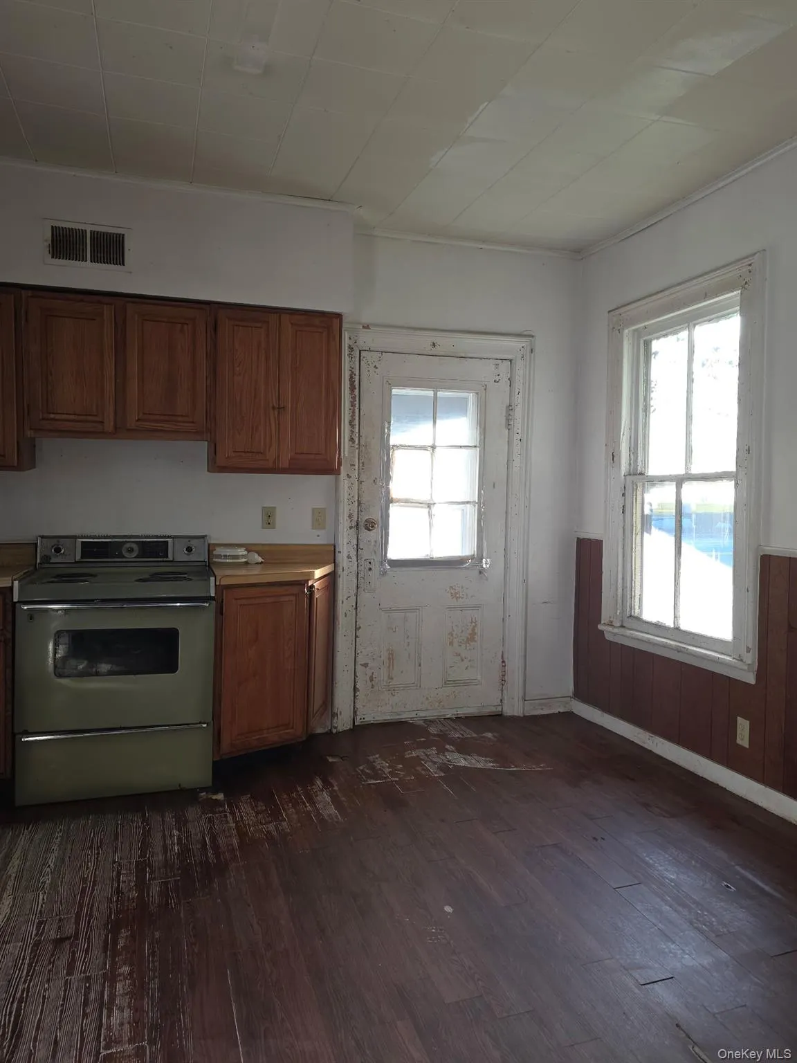 Kitchen featuring range with electric cooktop, healthy amount of natural light, light countertops, and dark wood-style floors Kitchen featuring range with electric cooktop, healthy amount of natural light, light countertops, and dark wood-style floors