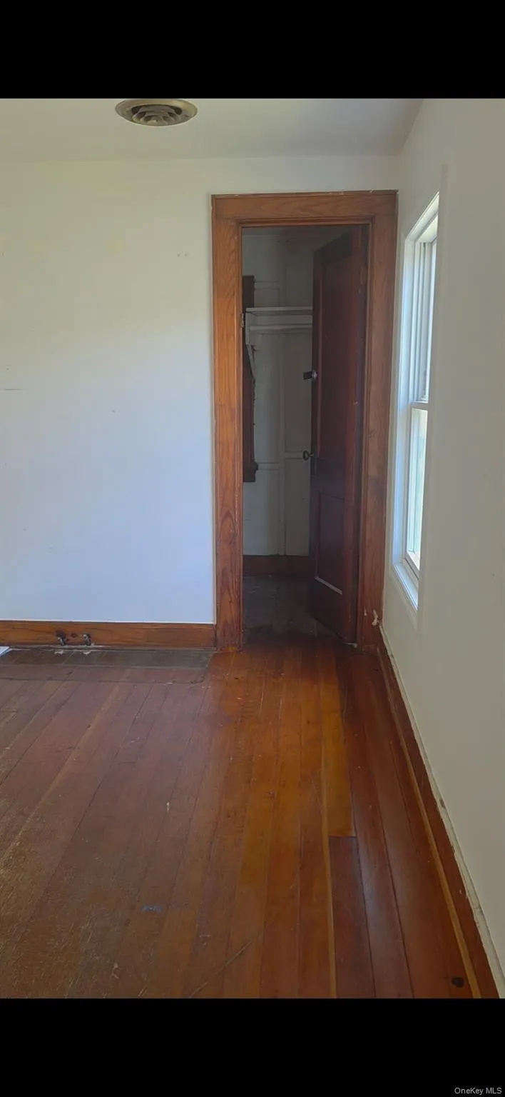 Hall featuring baseboards and hardwood / wood-style floors Hall featuring baseboards and hardwood / wood-style floors