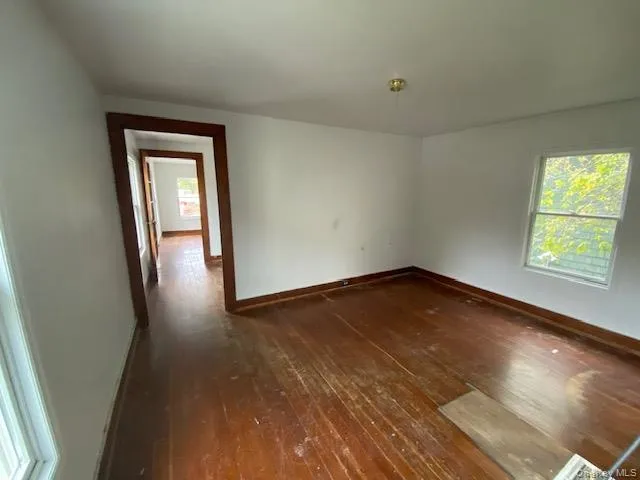 Spare room with dark wood finished floors and baseboards Spare room with dark wood finished floors and baseboards