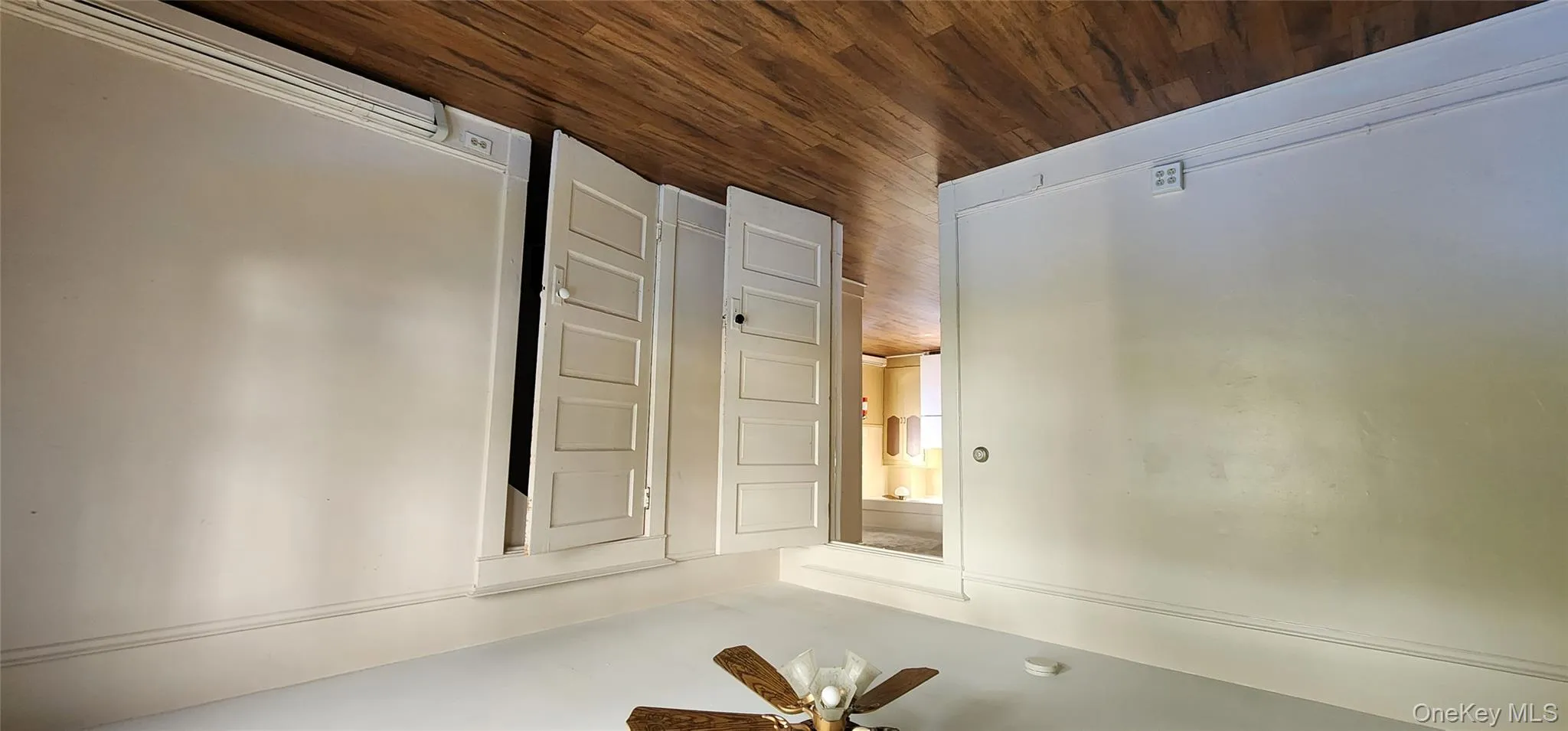Unfurnished bedroom featuring dark wood finished floors, baseboard heating, a ceiling fan, and a closet Unfurnished bedroom featuring dark wood finished floors, baseboard heating, a ceiling fan, and a closet