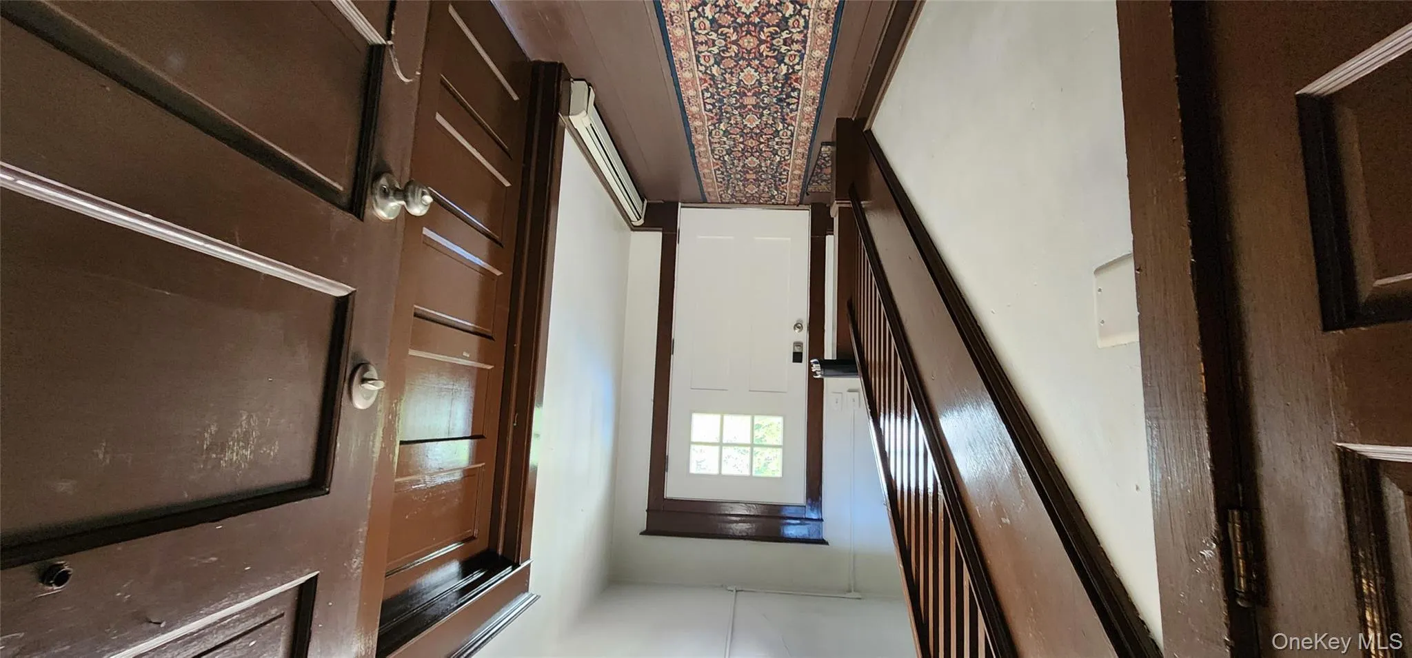 Doorway featuring a baseboard radiator and wood finished floors Doorway featuring a baseboard radiator and wood finished floors