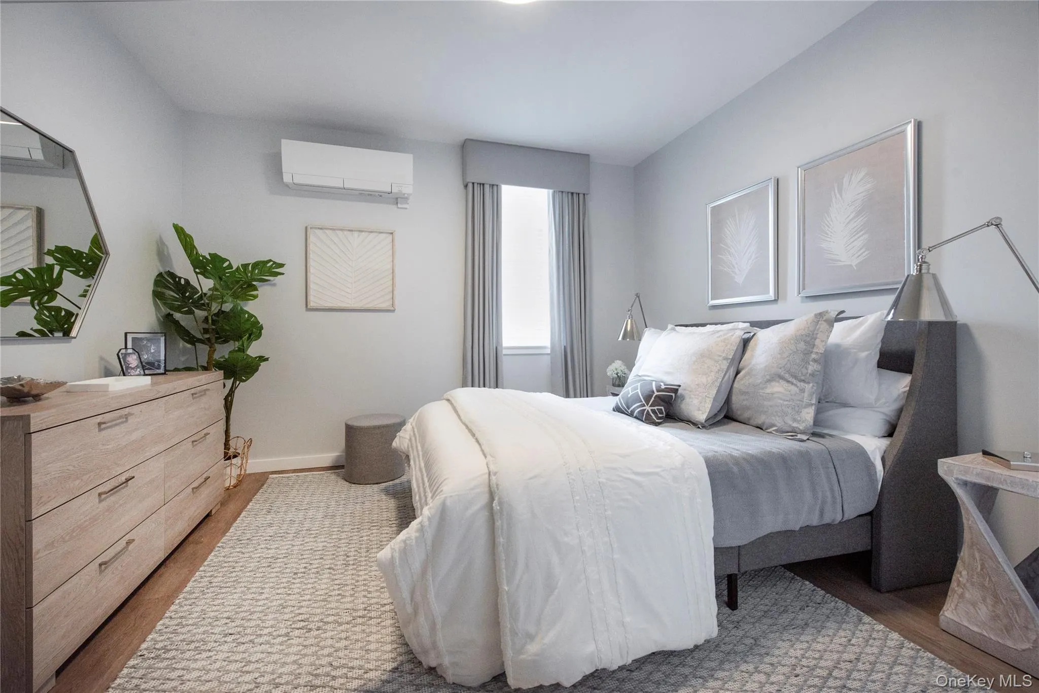 Bedroom featuring wood finished floors and a wall unit AC Bedroom featuring wood finished floors and a wall unit AC