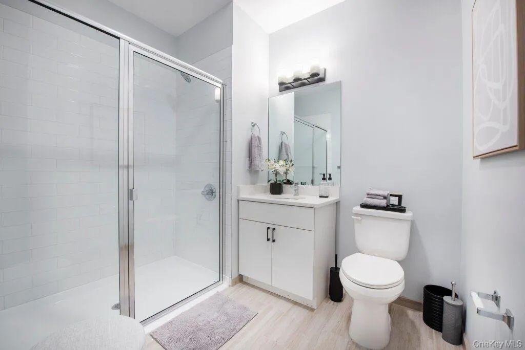 Bathroom with a shower stall, vanity, and light wood-style floors Bathroom with a shower stall, vanity, and light wood-style floors