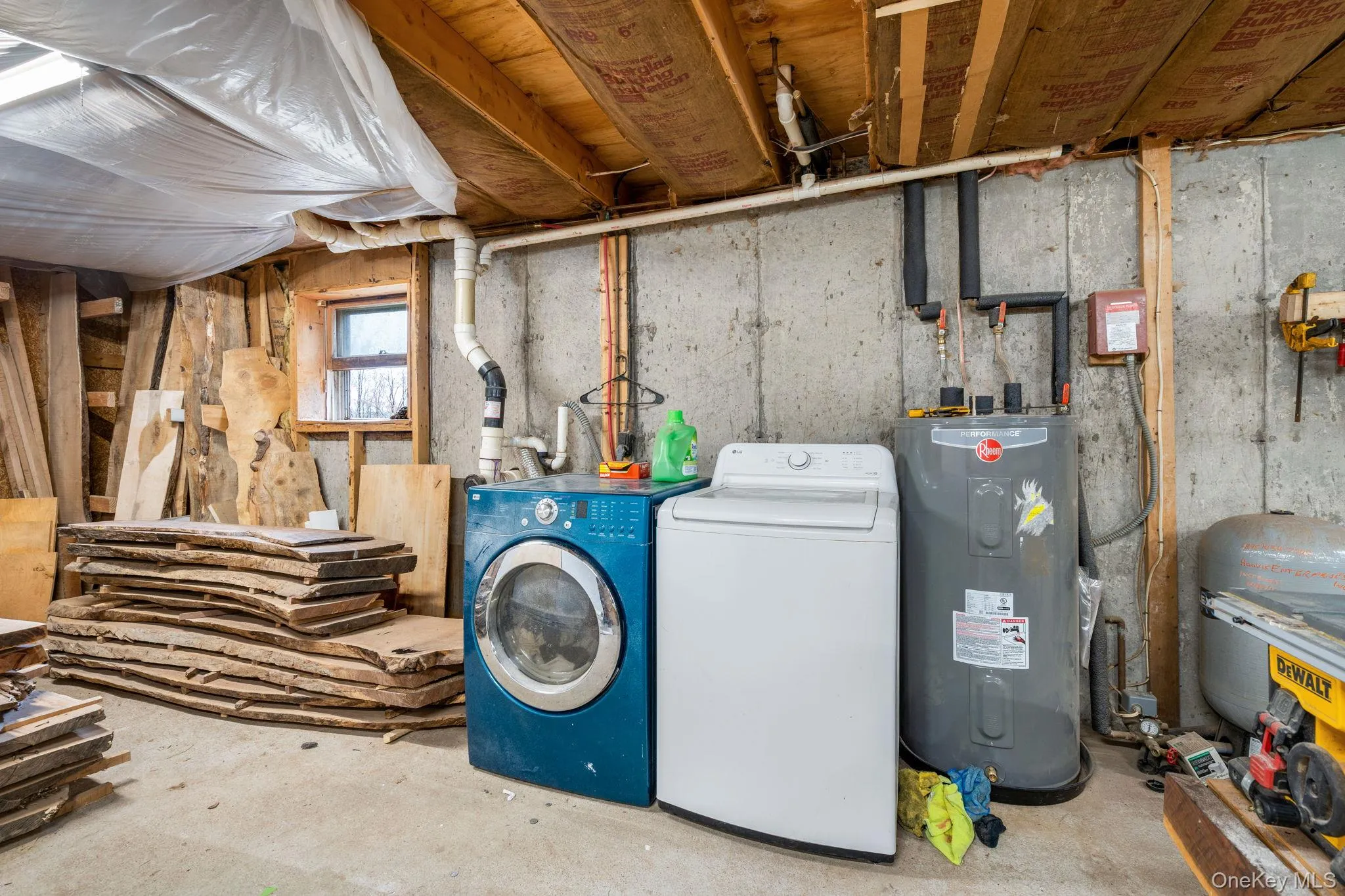 Laundry room with electric water heater, separate washer and dryer, and concrete floors Laundry room with electric water heater, separate washer and dryer, and concrete floors