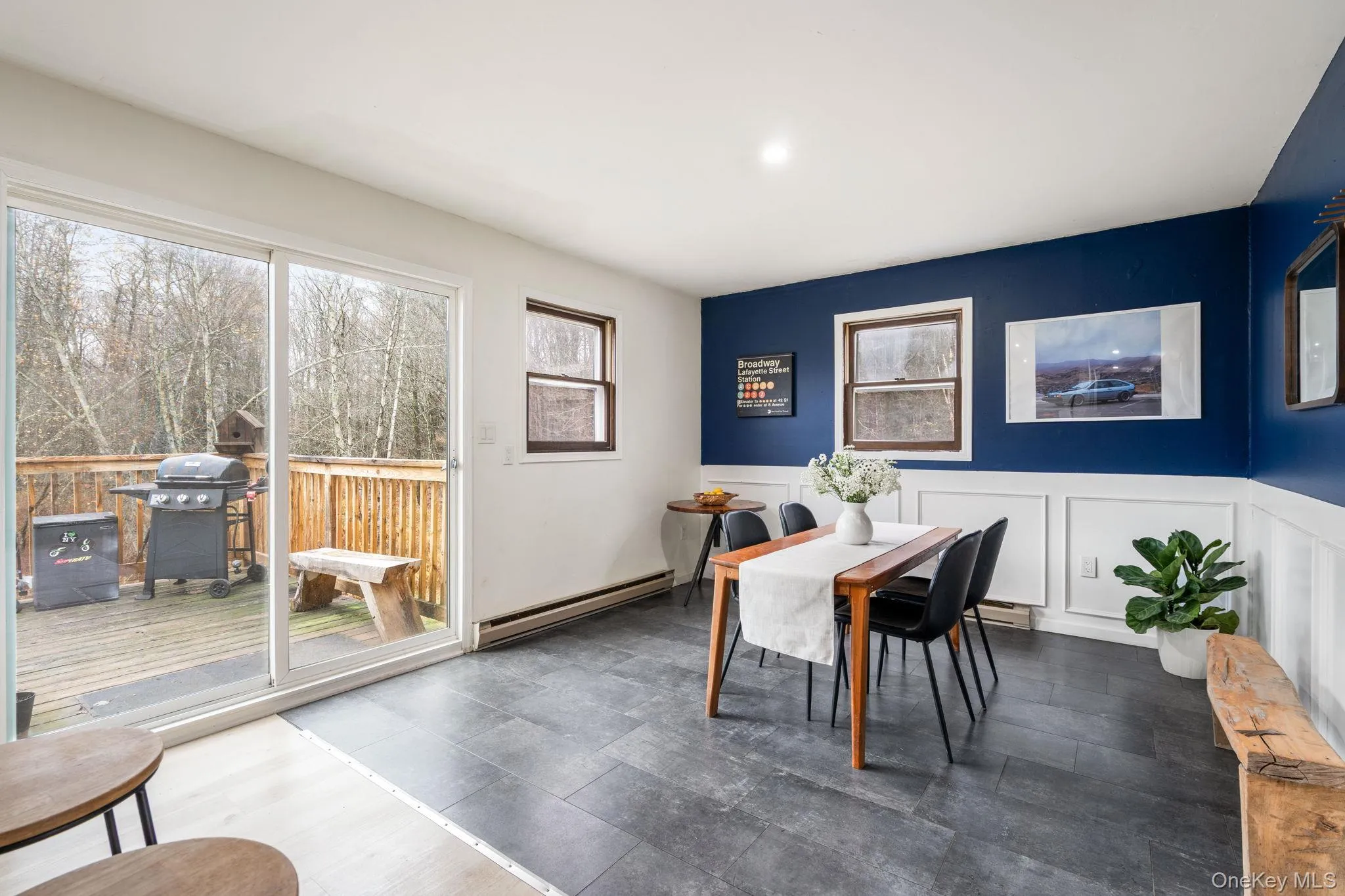 Dining space with baseboard heating, a decorative wall, and wainscoting Dining space with baseboard heating, a decorative wall, and wainscoting