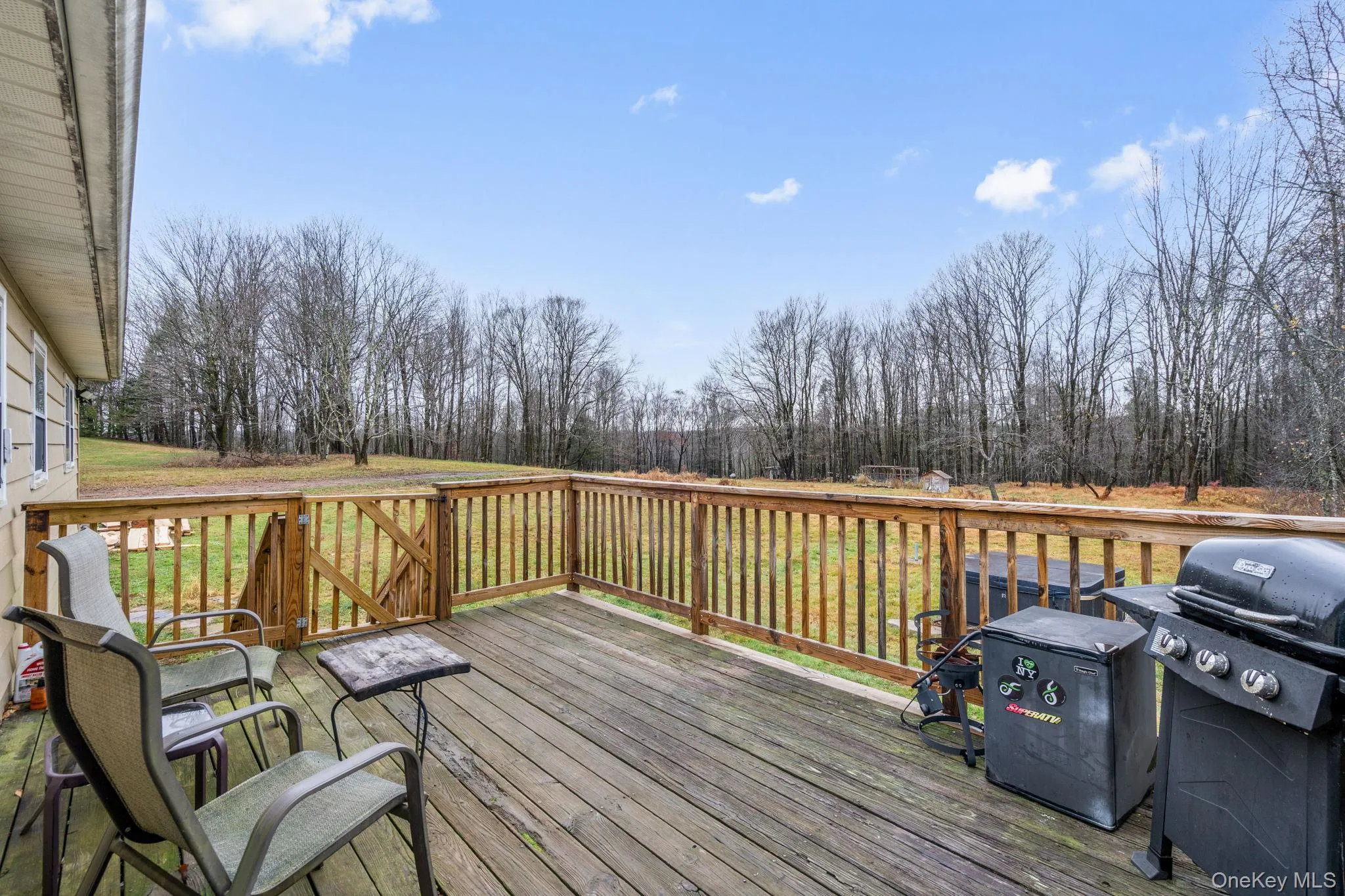 Deck with view of scattered trees, a grill, and a yard Deck with view of scattered trees, a grill, and a yard