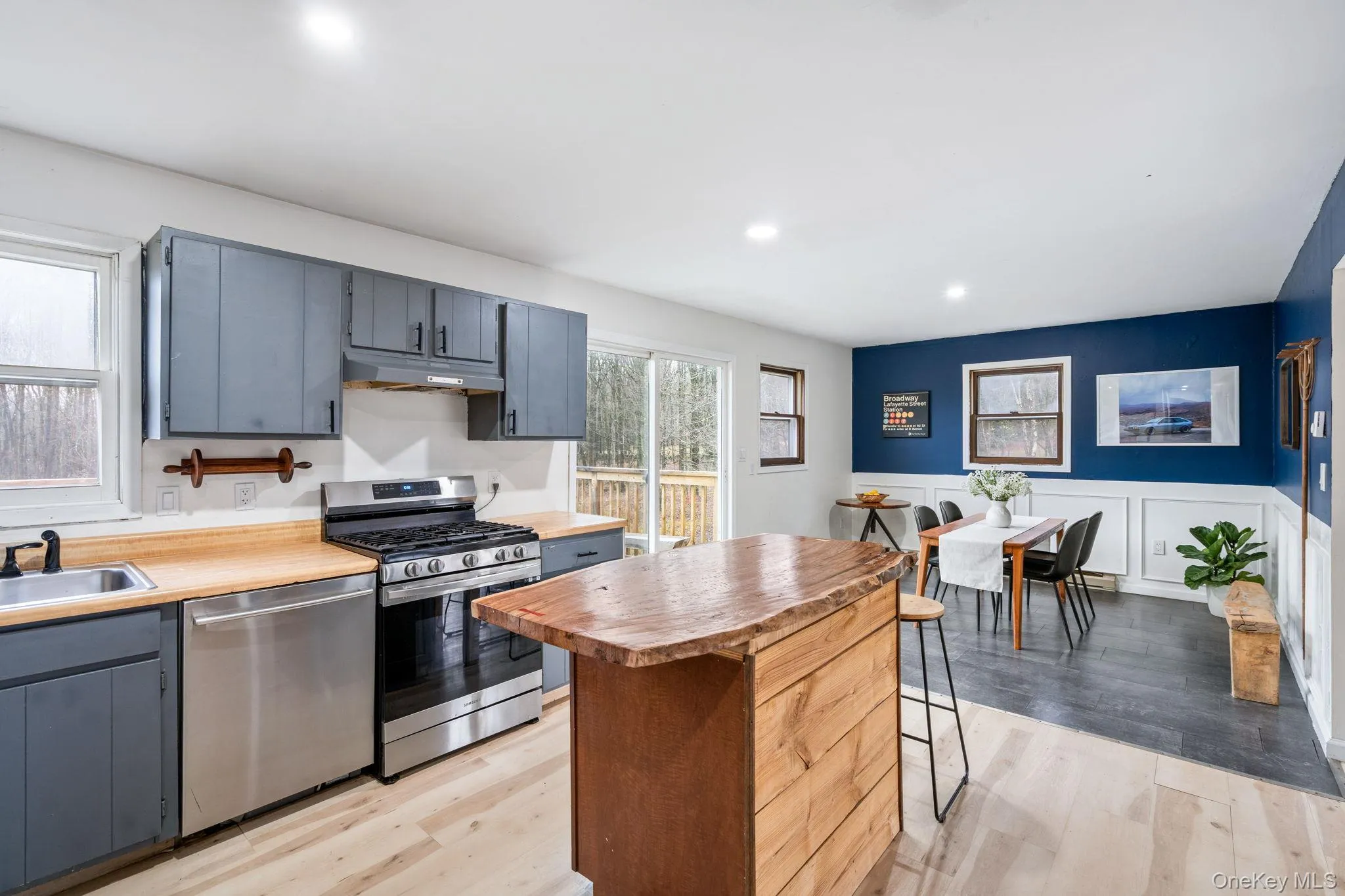 Kitchen featuring appliances with stainless steel finishes, plenty of natural light, wainscoting, light wood-style floors, and recessed lighting Kitchen featuring appliances with stainless steel finishes, plenty of natural light, wainscoting, light wood-style floors, and recessed lighting