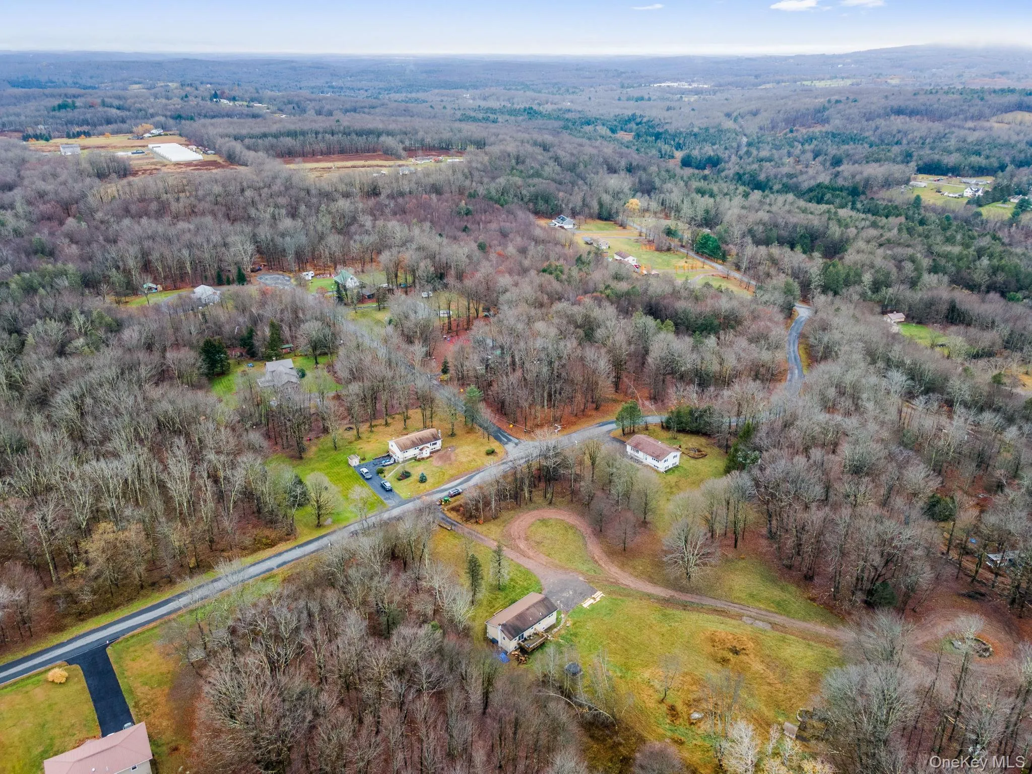 Aerial view of property and surrounding area featuring a heavily wooded area Aerial view of property and surrounding area featuring a heavily wooded area