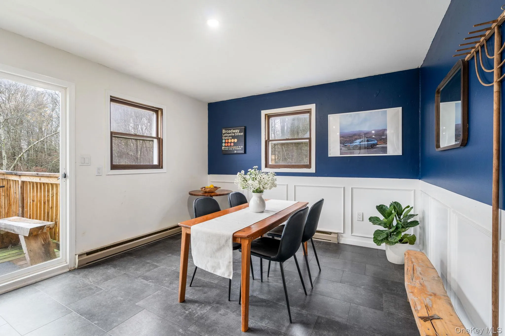 Dining room featuring a baseboard radiator, a decorative wall, and a wainscoted wall Dining room featuring a baseboard radiator, a decorative wall, and a wainscoted wall