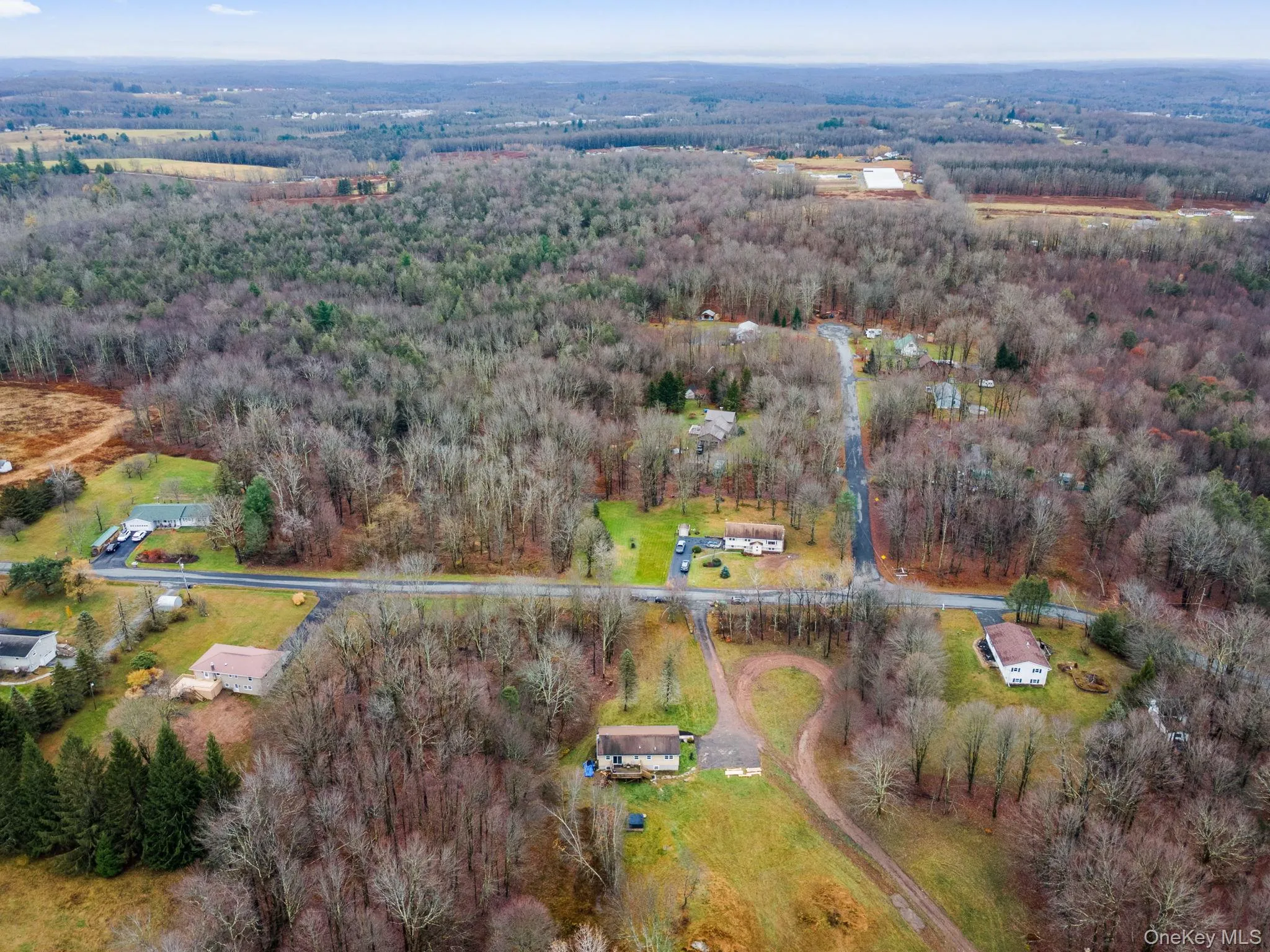 Aerial view of property and surrounding area featuring a heavily wooded area Aerial view of property and surrounding area featuring a heavily wooded area