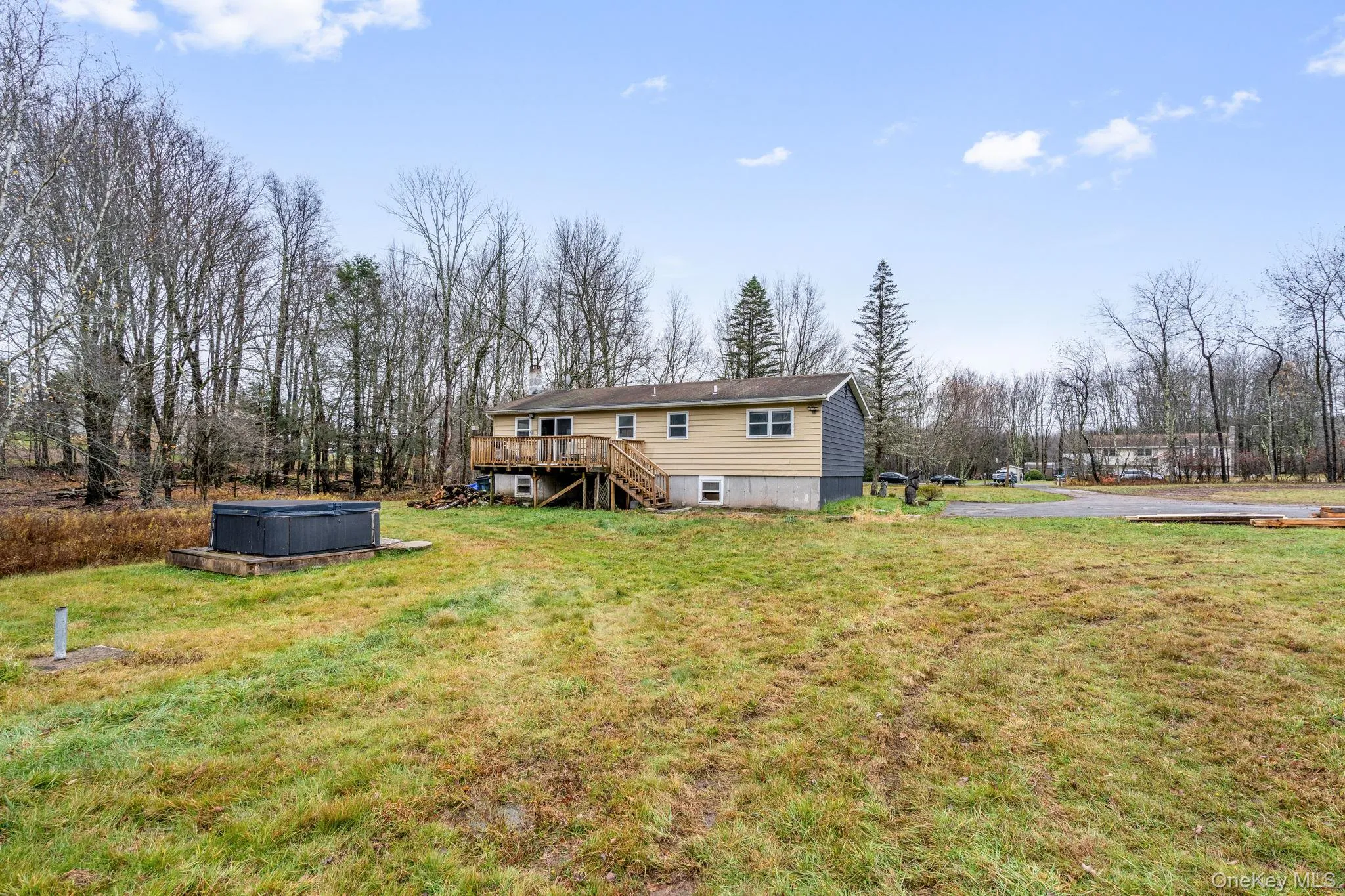 Back of house featuring stairs, a lawn, and a wooden deck Back of house featuring stairs, a lawn, and a wooden deck