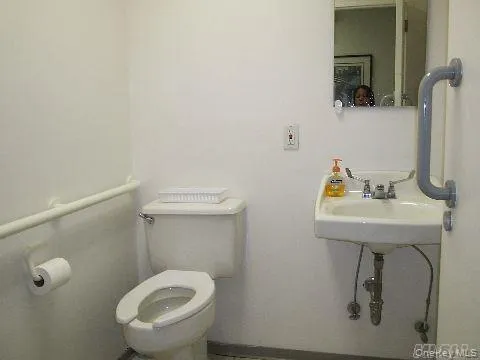 Half bathroom featuring toilet and baseboards Half bathroom featuring toilet and baseboards
