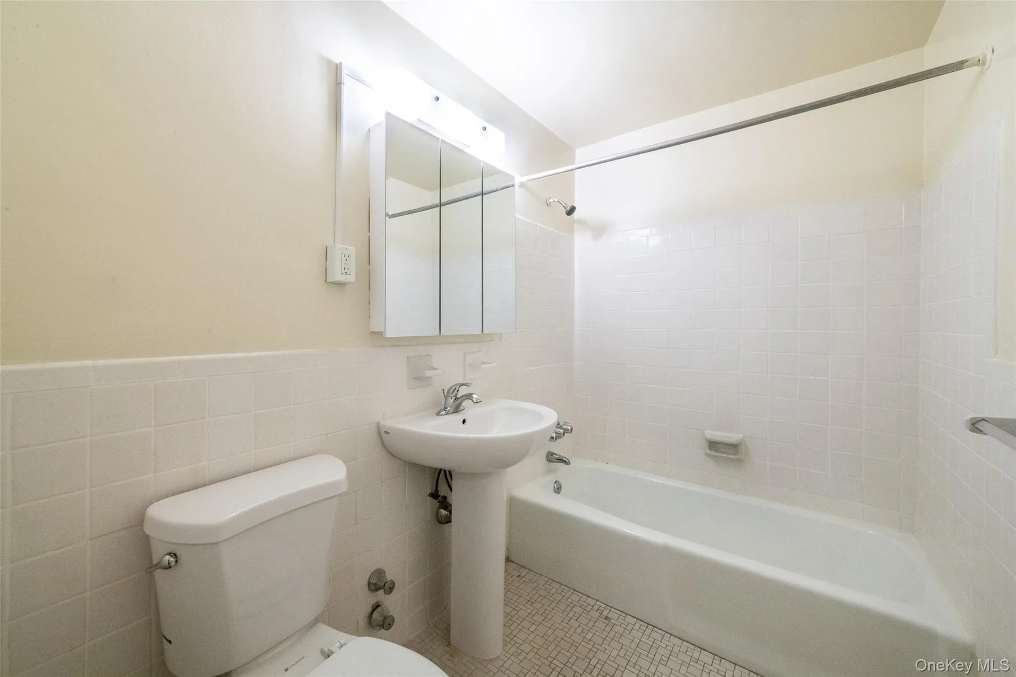 Bathroom featuring shower/tub combination, pedestal sink, medicine cabinet, tile walls and flooring (tile finishes vary depending on unit) Bathroom featuring shower/tub combination, pedestal sink, medicine cabinet, tile walls and flooring (tile finishes vary depending on unit)