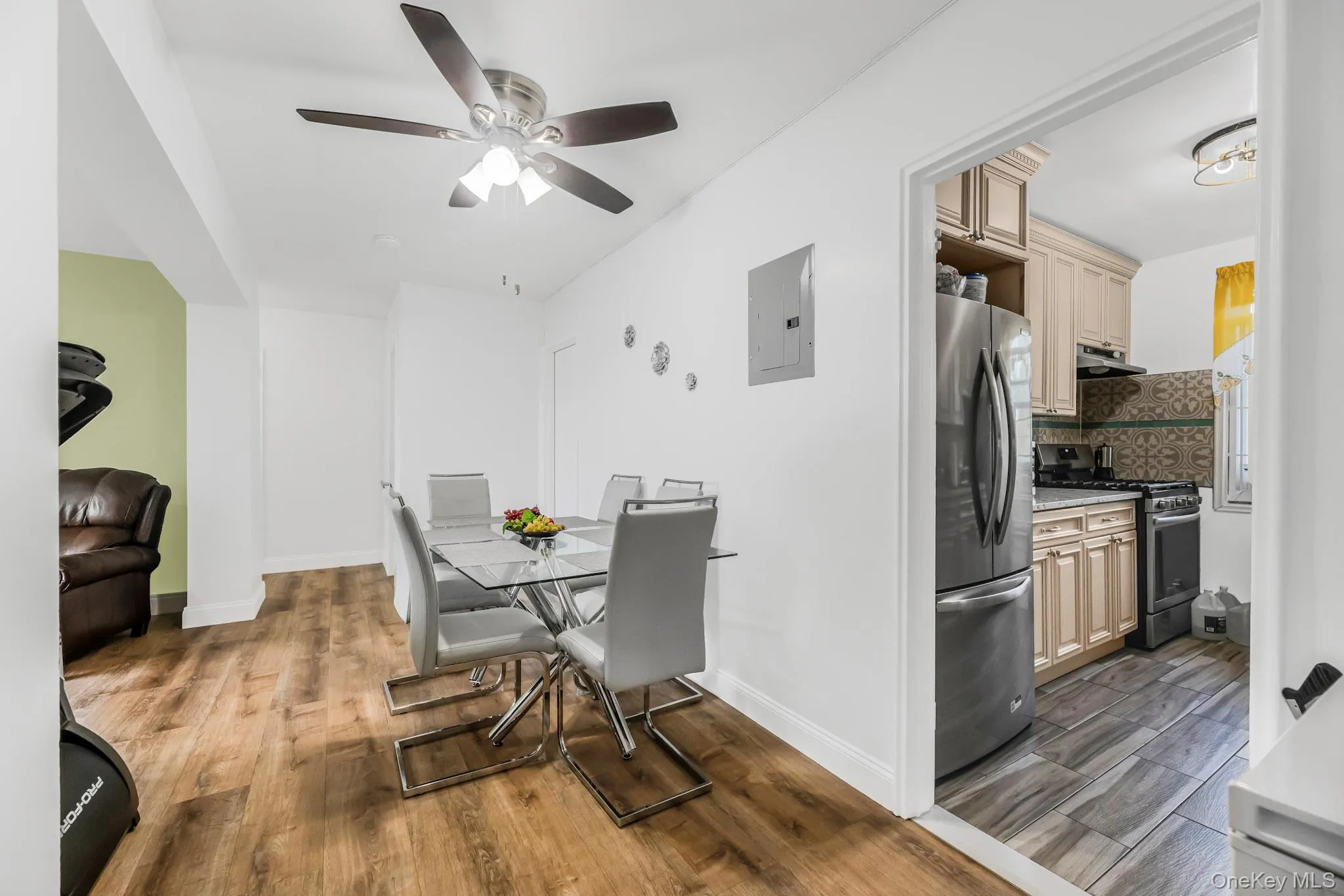 Dining room with dark wood-type flooring, electric panel, and ceiling fan Dining room with dark wood-type flooring, electric panel, and ceiling fan