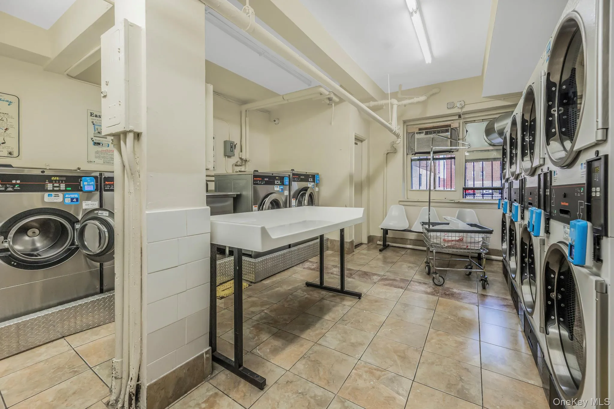 Community laundry featuring washing machine and dryer, stacked washer and clothes dryer, and water heater Community laundry featuring washing machine and dryer, stacked washer and clothes dryer, and water heater
