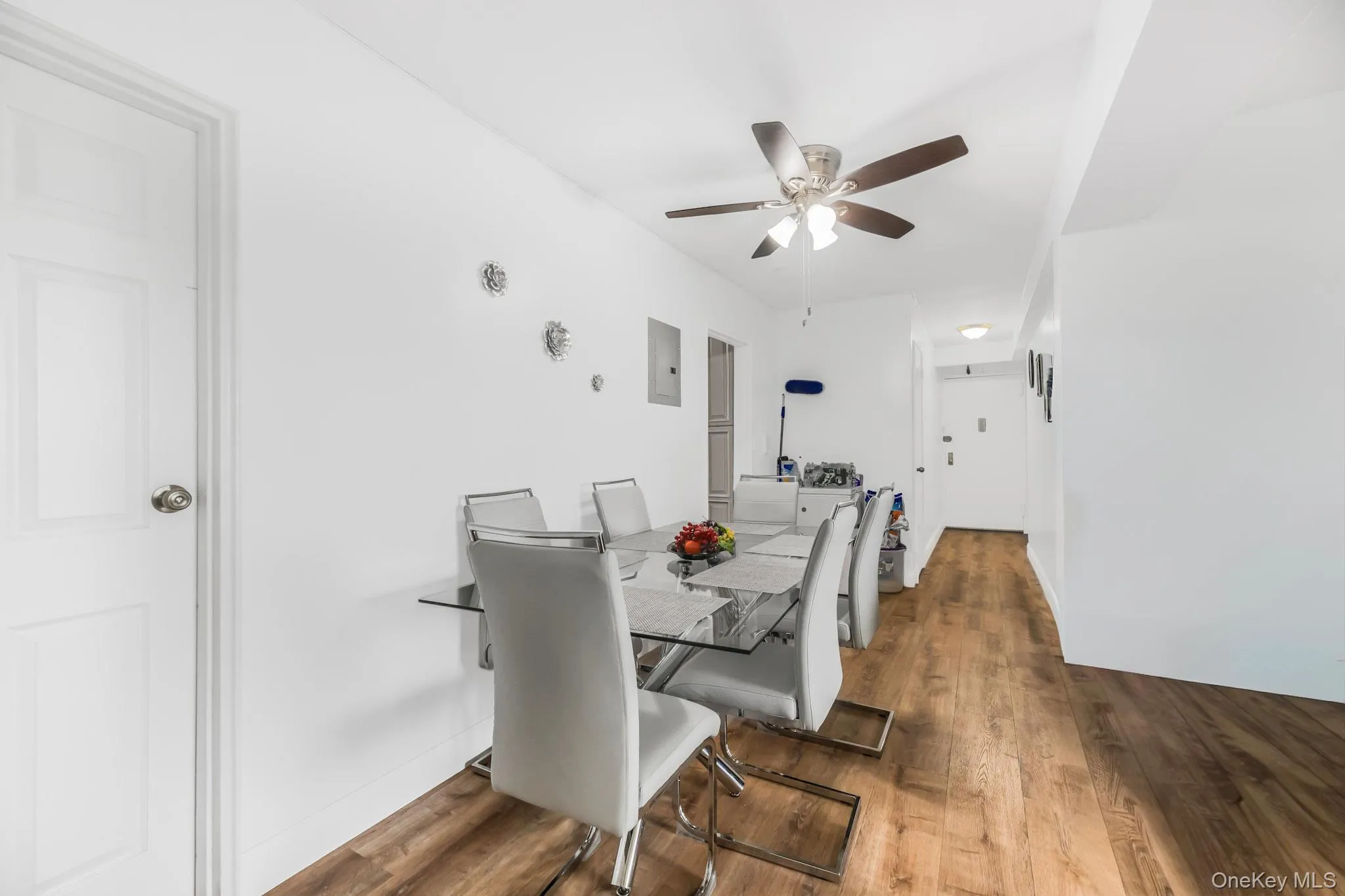 Dining room with dark wood-type flooring, a ceiling fan, and electric panel Dining room with dark wood-type flooring, a ceiling fan, and electric panel