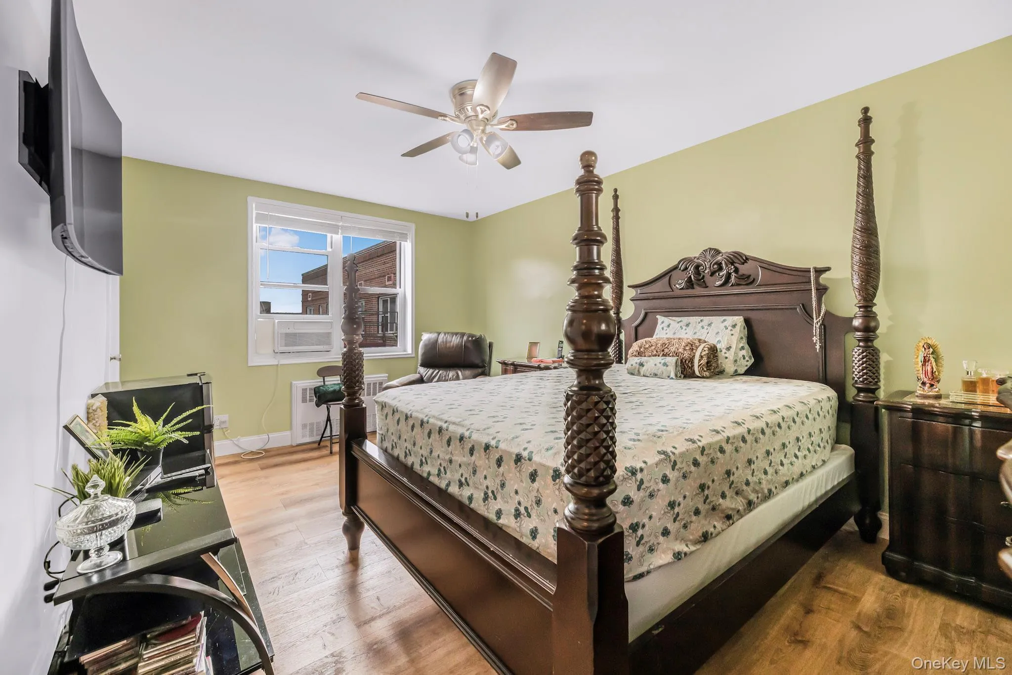 Bedroom with wood finished floors, radiator, and ceiling fan Bedroom with wood finished floors, radiator, and ceiling fan