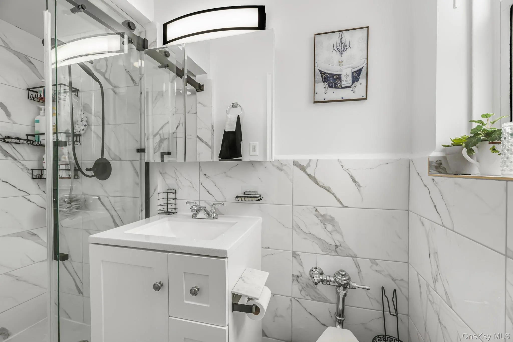 Full bathroom with vanity, a marble finish shower, and tile walls Full bathroom with vanity, a marble finish shower, and tile walls