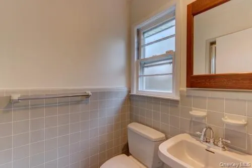 Bathroom featuring tile walls and a wainscoted wall Bathroom featuring tile walls and a wainscoted wall
