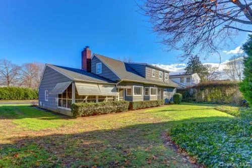 View of property exterior with a yard and a chimney View of property exterior with a yard and a chimney