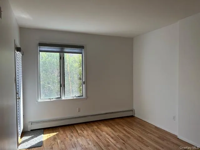 Spare room with a baseboard heating unit and light wood-type flooring Spare room with a baseboard heating unit and light wood-type flooring