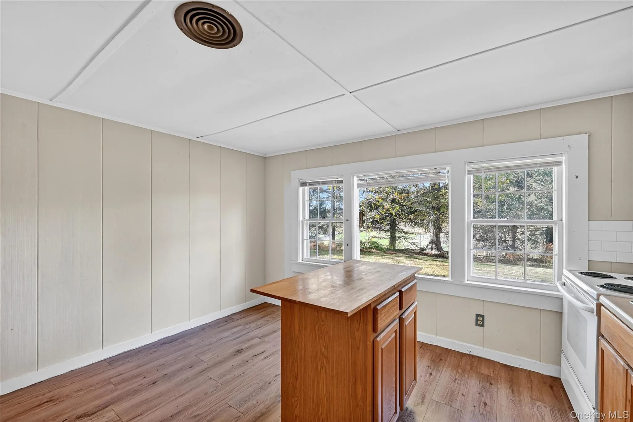 Kitchen featuring brown cabinetry, light wood-style flooring, wooden counters, and healthy amount of natural light Kitchen featuring brown cabinetry, light wood-style flooring, wooden counters, and healthy amount of natural light