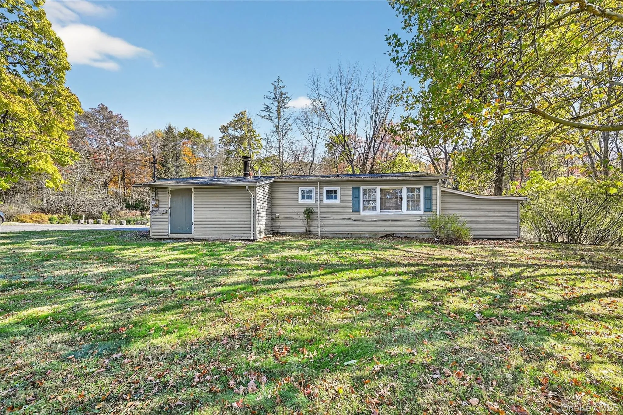 Rear view of house with a yard and view of scattered trees Rear view of house with a yard and view of scattered trees