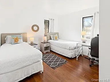 Bedroom with dark wood-style floors and an office area Bedroom with dark wood-style floors and an office area
