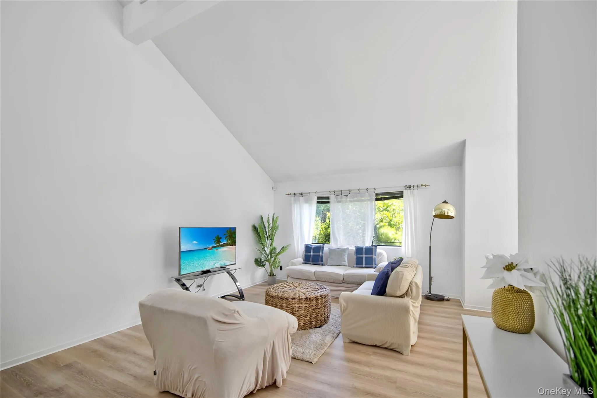 Living room featuring light wood finished floors, high vaulted ceiling, and beamed ceiling Living room featuring light wood finished floors, high vaulted ceiling, and beamed ceiling