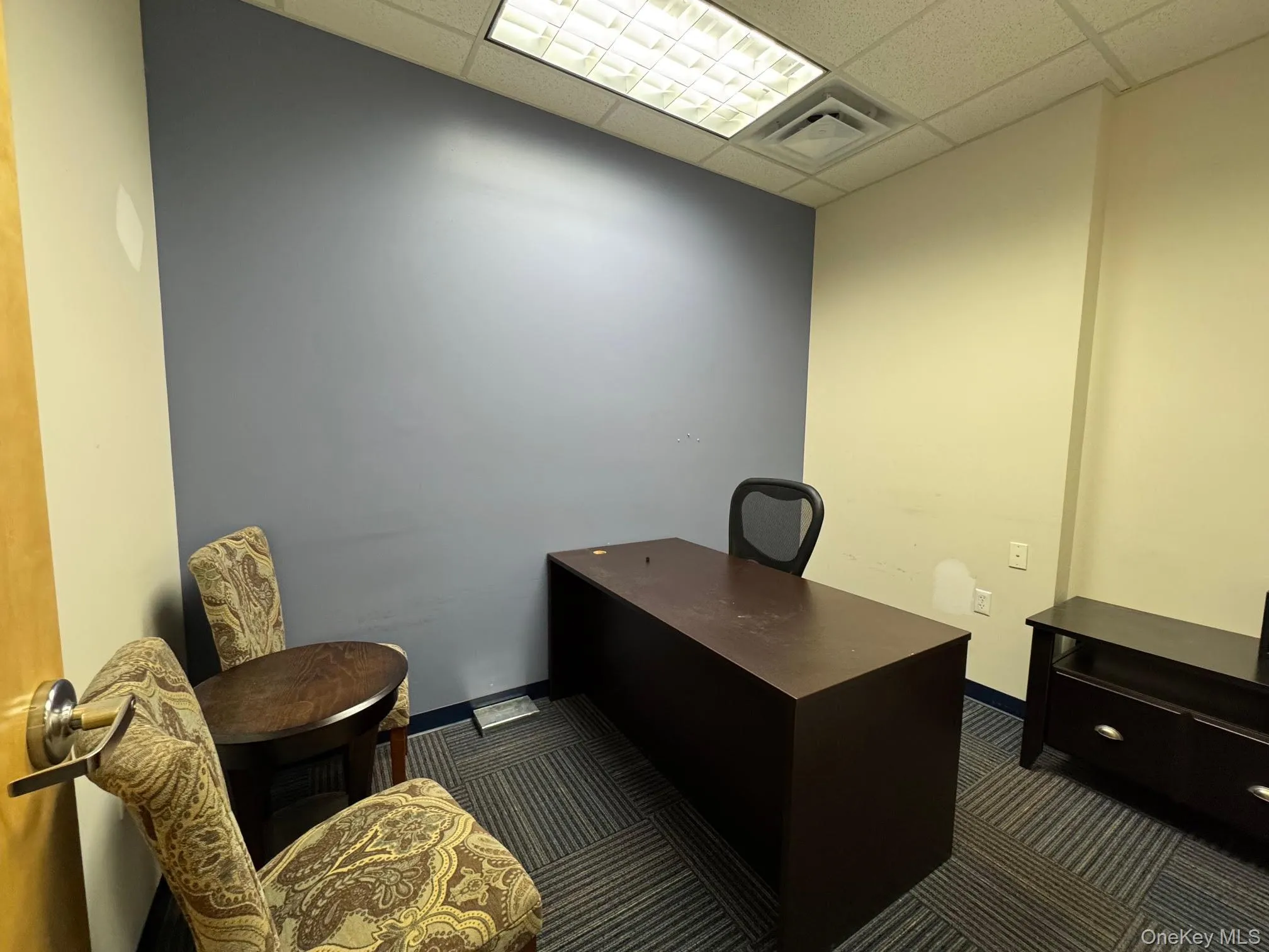 Office featuring a drop ceiling and dark carpet Office featuring a drop ceiling and dark carpet