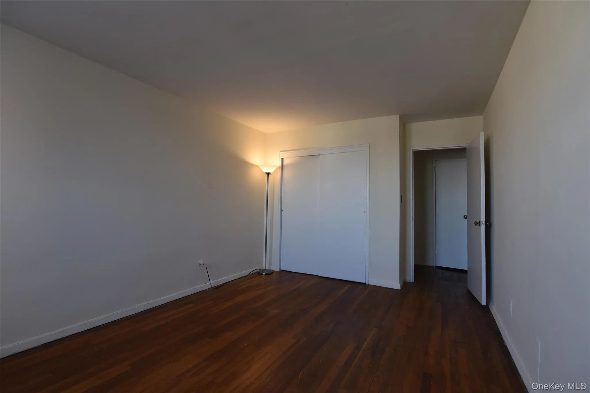 Unfurnished bedroom featuring dark wood-style floors and a closet Unfurnished bedroom featuring dark wood-style floors and a closet