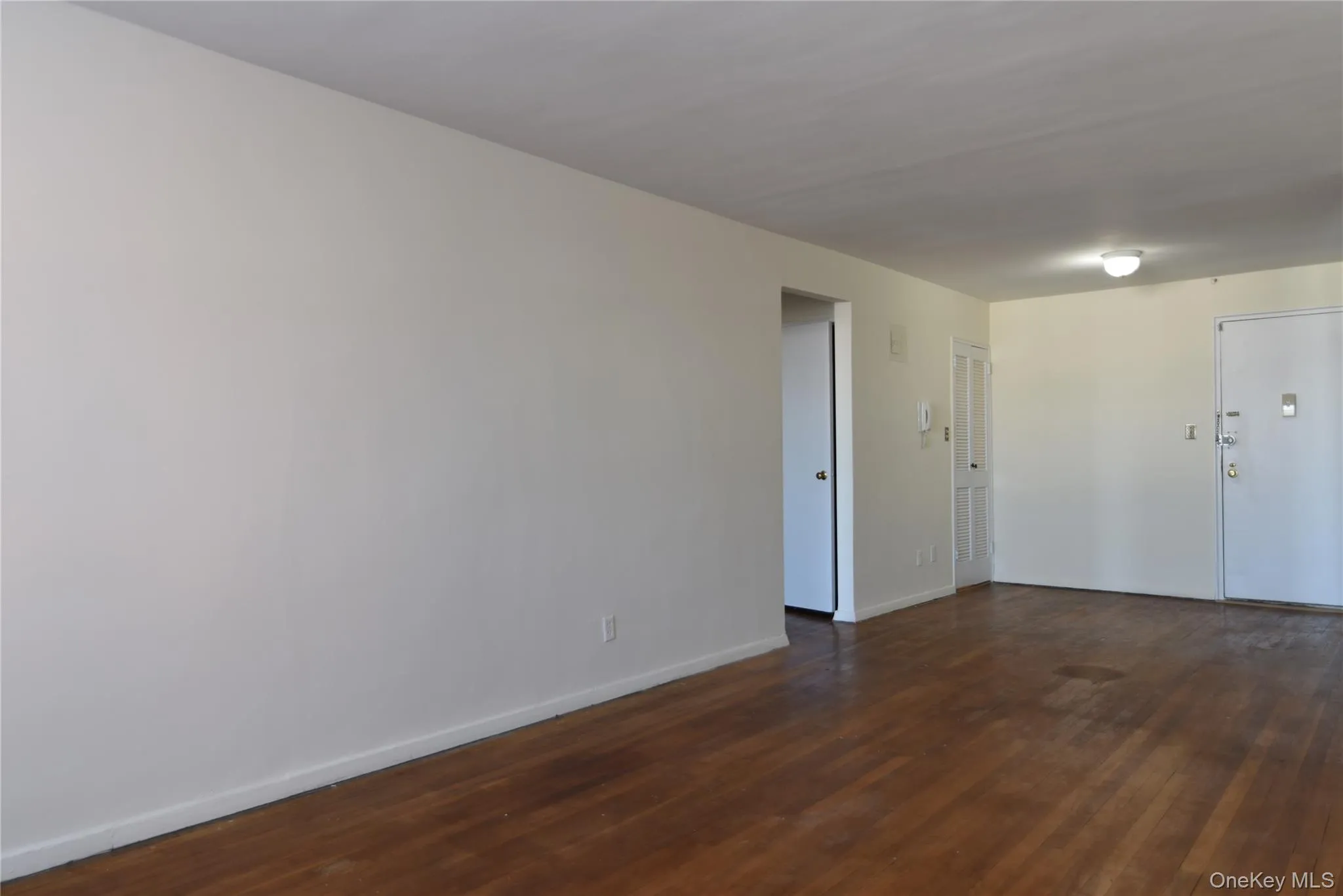 Unfurnished room featuring dark wood-type flooring and baseboards Unfurnished room featuring dark wood-type flooring and baseboards