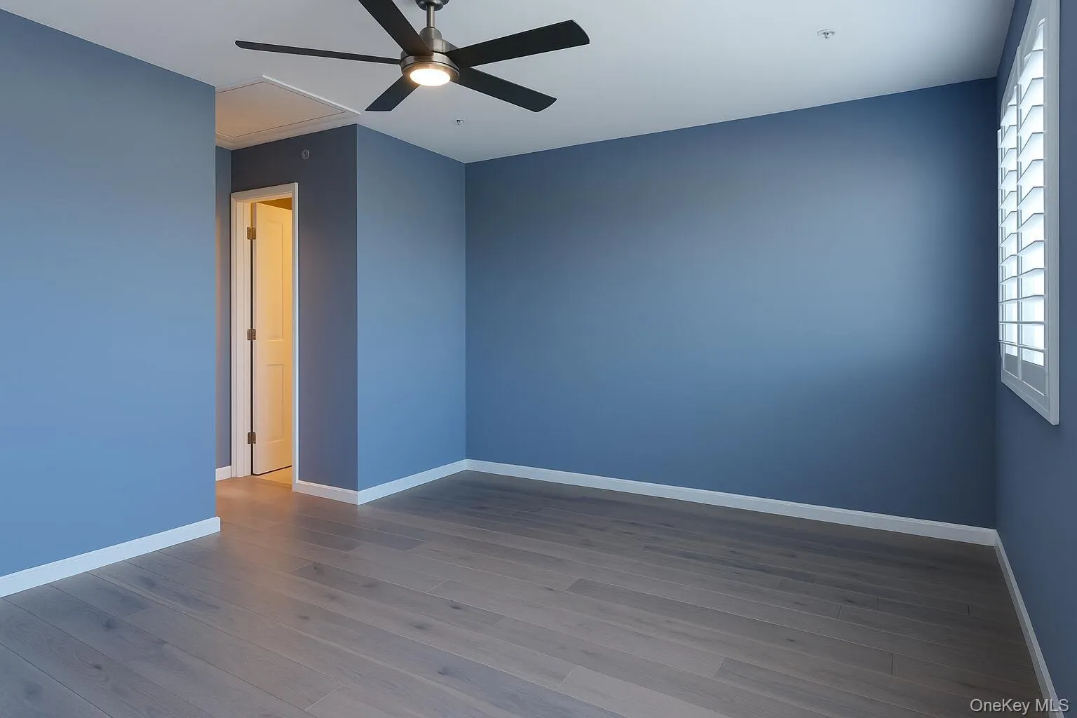 Empty room featuring dark wood-style floors and ceiling fan Empty room featuring dark wood-style floors and ceiling fan