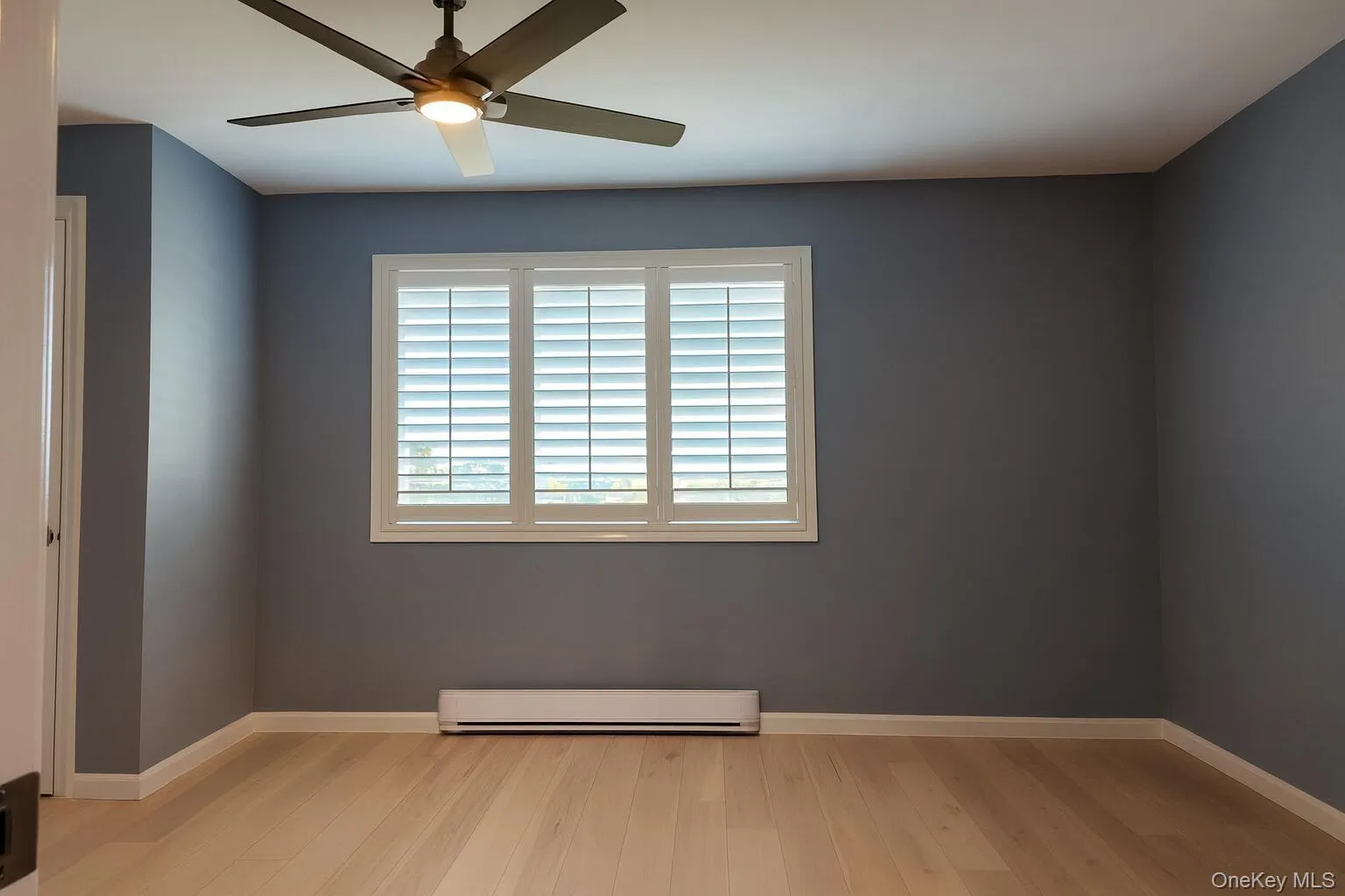 Spare room featuring light wood-style flooring, baseboard heating, and ceiling fan Spare room featuring light wood-style flooring, baseboard heating, and ceiling fan