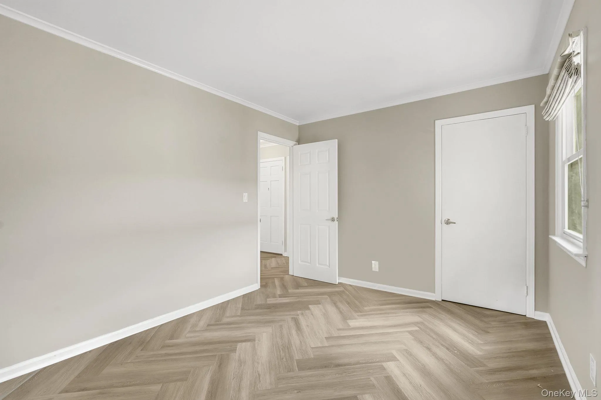 Unfurnished bedroom with baseboards and crown molding Unfurnished bedroom with baseboards and crown molding