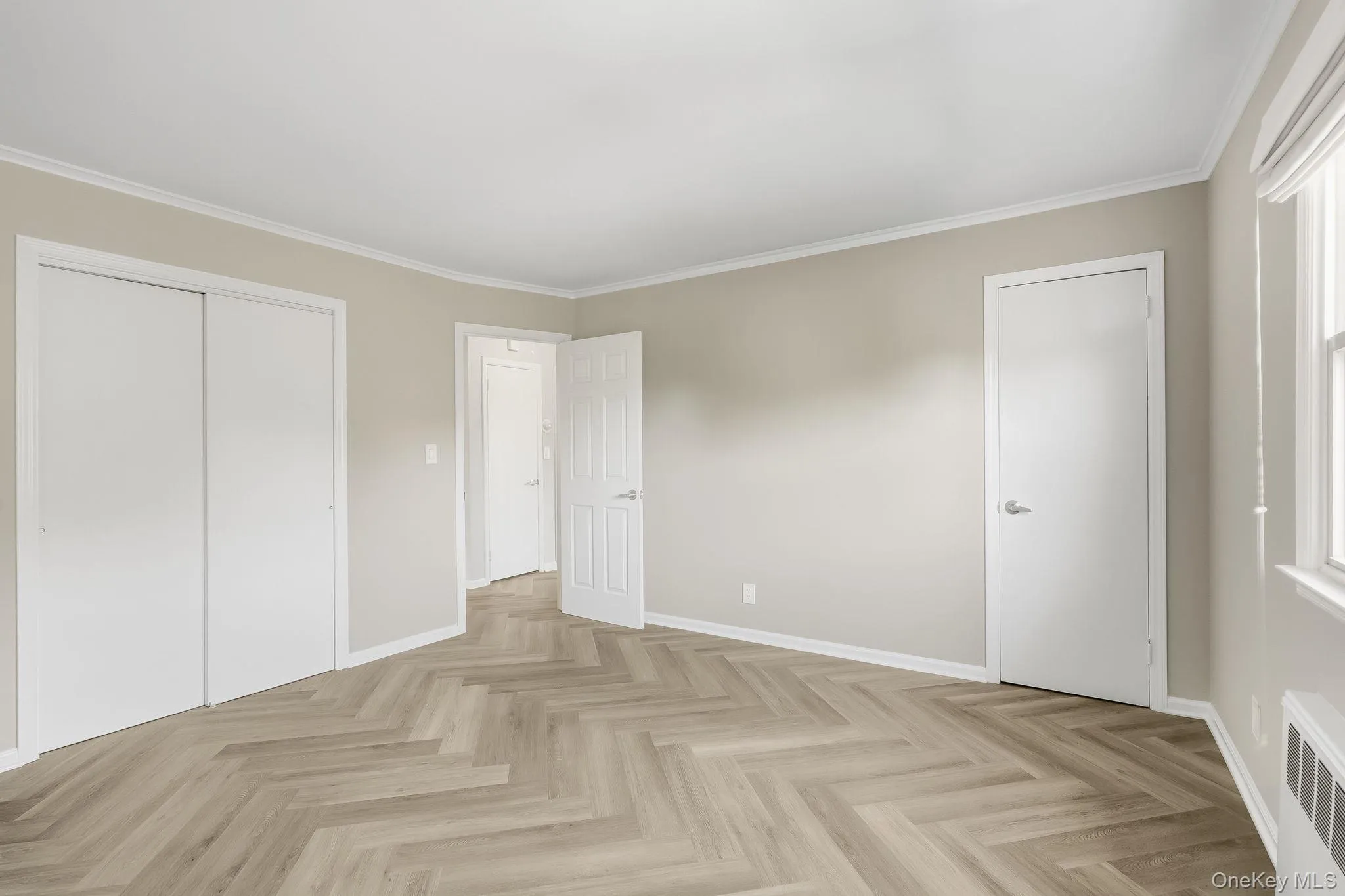 Unfurnished bedroom featuring crown molding, radiator, and a closet Unfurnished bedroom featuring crown molding, radiator, and a closet