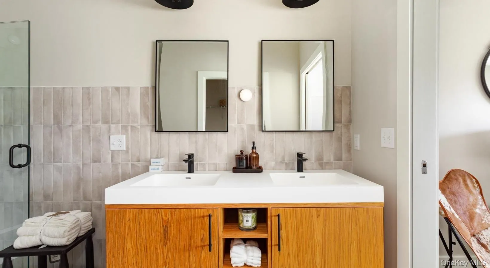 Full bath with tile walls, a shower stall, and double vanity Full bath with tile walls, a shower stall, and double vanity