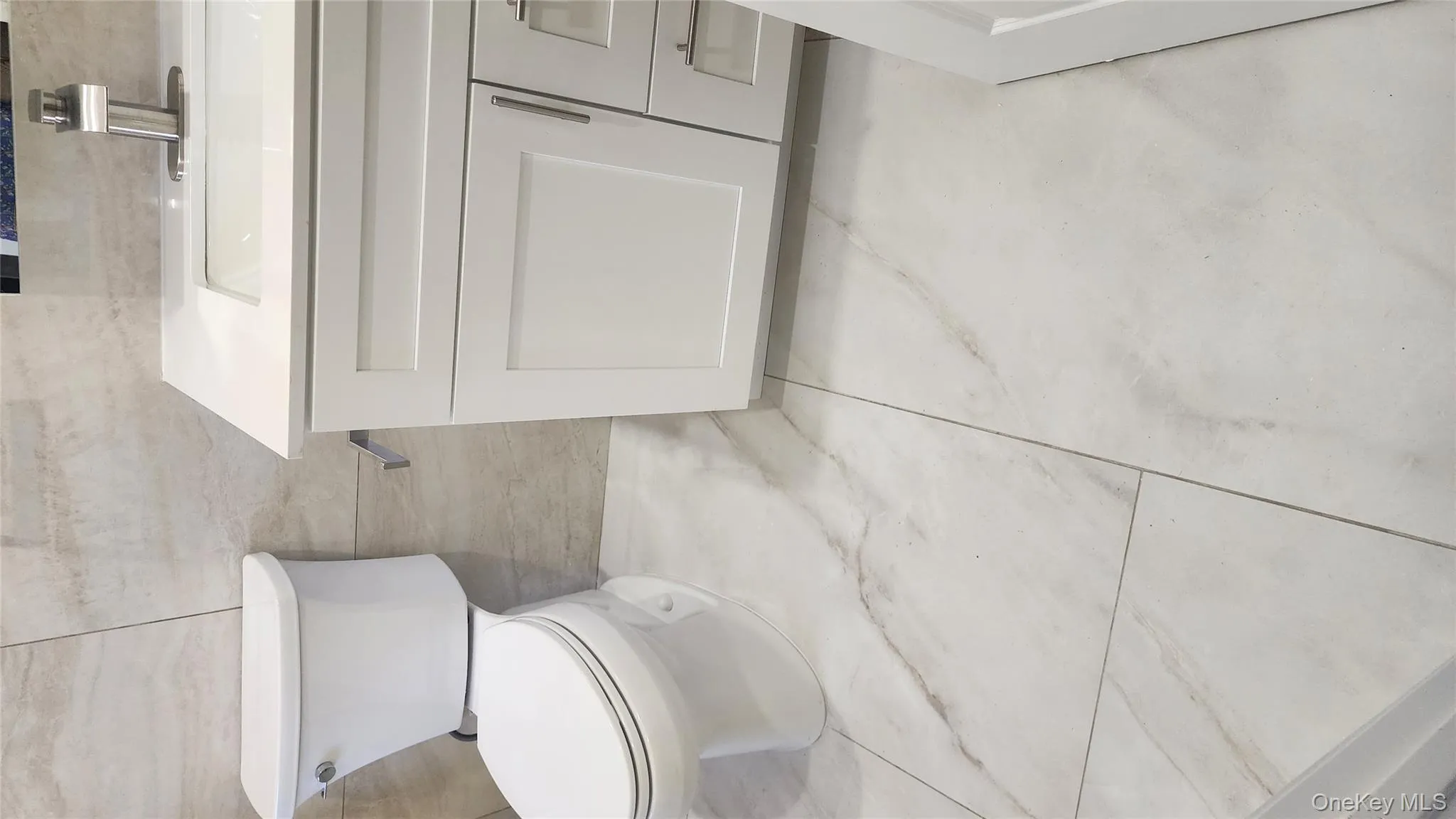 Bathroom featuring vanity, tile walls, and light tile patterned flooring Bathroom featuring vanity, tile walls, and light tile patterned flooring