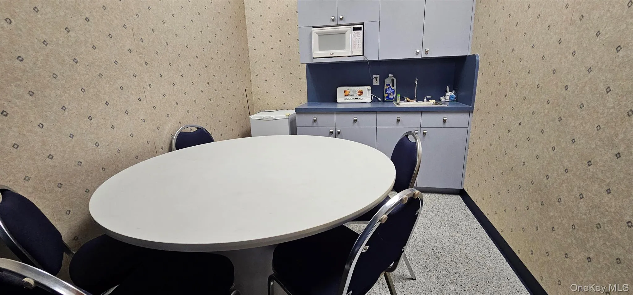 Dining room featuring wallpapered walls and baseboards Dining room featuring wallpapered walls and baseboards