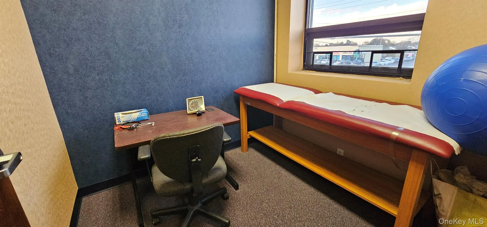 Office area featuring carpet and a textured wall Office area featuring carpet and a textured wall